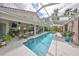 A long, rectangular pool is flanked by a patio with lounge chairs and tropical plants at 6467 Rubia Cir, Apollo Beach, FL 33572