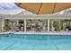 Outdoor pool area featuring an umbrella, a variety of seating, and access to an outdoor living space at 6467 Rubia Cir, Apollo Beach, FL 33572