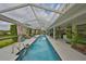 Relaxing view of a rectangular pool surrounded by a patio, with chairs and tropical plants at 6467 Rubia Cir, Apollo Beach, FL 33572