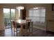 Bright dining room with sliding glass doors to a patio, white table and seating for four at 6513 Sand Shore Ln, New Port Richey, FL 34652