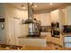 Modern kitchen with stainless steel appliances, granite countertops, and a central island cooktop with range hood at 6513 Sand Shore Ln, New Port Richey, FL 34652