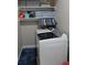 Bright laundry room with white shelving, decorative containers, and a washing machine at 6513 Sand Shore Ln, New Port Richey, FL 34652