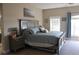 Spacious main bedroom featuring a large bed, nightstands, and a door to the outside at 6513 Sand Shore Ln, New Port Richey, FL 34652