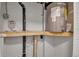 Utility room showcasing water heater, water shutoff valve, and a timer controller all resting on a wooden shelf at 7 Georgia Ave, Crystal Beach, FL 34681