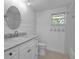 Bright bathroom featuring a marble vanity top, stylish mirror, and classic black and white patterned tile at 7 Georgia Ave, Crystal Beach, FL 34681