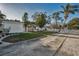 Concrete driveway leading to home with manicured lawn, shed, and white picket fence at 7 Georgia Ave, Crystal Beach, FL 34681