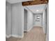 Bright hallway featuring light wood-look flooring and a rustic wood beam detail above an open doorway at 7 Georgia Ave, Crystal Beach, FL 34681