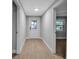 Bright hallway featuring light wood-look flooring, white doors, and neutral paint at 7 Georgia Ave, Crystal Beach, FL 34681