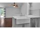 Kitchen area with a farmhouse sink and stainless steel dishwasher, open to the living area at 7 Georgia Ave, Crystal Beach, FL 34681