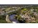 An aerial view of a home situated along a winding canal surrounded by lush trees and neighboring houses at 8001 Orient Ne Way, St Petersburg, FL 33702