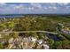 An aerial view highlights a home near a pond in a neighborhood with clear skies and stunning distant water views at 8001 Orient Ne Way, St Petersburg, FL 33702