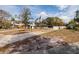 View of house with an attached one car garage on a large grassy lot and mature landscaping at 8001 Orient Ne Way, St Petersburg, FL 33702
