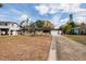 View of house with an attached one car garage on a large grassy lot and mature landscaping at 8001 Orient Ne Way, St Petersburg, FL 33702