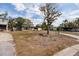 View of home with an expansive lawn, an attached one car garage, and mature trees on a sunny day at 8001 Orient Ne Way, St Petersburg, FL 33702