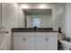 Bathroom featuring a double sink granite vanity with white cabinets and a large mirror at 8294 Corner Pine Way, New Port Richey, FL 34655