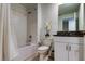 Bathroom featuring a shower-tub combo, toilet, and a granite-top vanity with white cabinets at 8294 Corner Pine Way, New Port Richey, FL 34655
