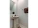 Powder room with a pedestal sink, stylish mirror, neutral color scheme, and tiled flooring at 8294 Corner Pine Way, New Port Richey, FL 34655