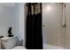 Bathroom with a black shower curtain and a tiled shower with a hand-held shower head at 8294 Corner Pine Way, New Port Richey, FL 34655
