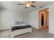 Bedroom featuring gray carpet, a ceiling fan, a queen bed with white bedding, and a doorway at 8294 Corner Pine Way, New Port Richey, FL 34655