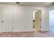 Bedroom with neutral carpet, open doorway to ensuite bathroom and a large closet at 8294 Corner Pine Way, New Port Richey, FL 34655