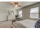 Well-lit bedroom featuring gray carpet, a ceiling fan, a dresser, and two windows for natural light at 8294 Corner Pine Way, New Port Richey, FL 34655