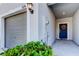 Close-up showcasing the entrance of a home, featuring a garage, front door, and decorative plants at 8294 Corner Pine Way, New Port Richey, FL 34655