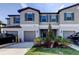 Charming townhome featuring a gray exterior, blue shutters, and well-maintained landscaping at 8294 Corner Pine Way, New Port Richey, FL 34655