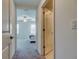 Hallway leads into a bedroom featuring a ceiling fan and a queen bed with white bedding at 8294 Corner Pine Way, New Port Richey, FL 34655