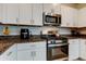 Modern kitchen featuring stainless steel appliances and white cabinets at 8294 Corner Pine Way, New Port Richey, FL 34655