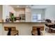 Kitchen offers breakfast bar with backyard views, white cabinets, and stainless steel appliances at 8294 Corner Pine Way, New Port Richey, FL 34655