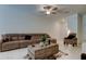 Cozy living room featuring tile floors, a ceiling fan, and comfortable seating at 8294 Corner Pine Way, New Port Richey, FL 34655