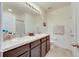 Well-lit bathroom featuring a dual sink vanity with granite countertops and ample storage at 8421 Pine River Rd, Tampa, FL 33637