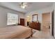 Well-lit bedroom with warm neutral colors, wooden furniture, and natural light from window at 8421 Pine River Rd, Tampa, FL 33637