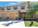 Charming two-story townhome with attached garage, beautiful shutters, and tropical landscaping at 8421 Pine River Rd, Tampa, FL 33637