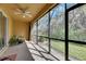 Relaxing sunroom with screened windows offering views of the lush greenery outside at 8421 Pine River Rd, Tampa, FL 33637
