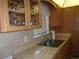 Practical kitchen featuring wooden cabinets, neutral countertops, and a stainless steel sink at 8525 111Th St # 210, Seminole, FL 33772