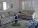 Inviting living room with a glass coffee table, sofas, and natural light from the white shuttered windows at 8525 111Th St # 210, Seminole, FL 33772
