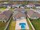 Aerial view showing the backyard's private pool, patio area, and neighborhood's water view at 8887 Little Bluestem Dr, Land O Lakes, FL 34637