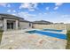 Covered patio overlooking backyard pool and hot tub with stone tile surround at 8887 Little Bluestem Dr, Land O Lakes, FL 34637