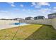 View of grassy backyard and the pool and hot tub with stone tile surround at 8887 Little Bluestem Dr, Land O Lakes, FL 34637