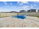 View of pool and hot tub with stone tile surround and view of neighboring homes at 8887 Little Bluestem Dr, Land O Lakes, FL 34637