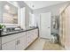 Well-lit bathroom with double sinks, granite countertops, pendant lighting, and a shower at 8887 Little Bluestem Dr, Land O Lakes, FL 34637