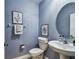 Powder room featuring blue walls, vanity, and a decorative mirror with nice lighting at 8887 Little Bluestem Dr, Land O Lakes, FL 34637