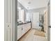 Bathroom with dual sinks, sleek mirrors, white cabinets, and a walk-in shower at 8887 Little Bluestem Dr, Land O Lakes, FL 34637