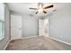 Bedroom showcasing carpeted floor, ceiling fan, white doors, and lots of natural light at 8887 Little Bluestem Dr, Land O Lakes, FL 34637
