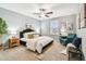 Bright bedroom with a ceiling fan, queen size bed, sitting chair, and natural light through the windows at 8887 Little Bluestem Dr, Land O Lakes, FL 34637