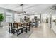 Open dining area with modern chandelier, table set for six, and view of living area at 8887 Little Bluestem Dr, Land O Lakes, FL 34637