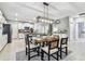 Open dining area with modern chandelier, table set for four, and kitchen views at 8887 Little Bluestem Dr, Land O Lakes, FL 34637
