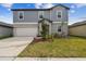 Charming two-story home showcasing a well-manicured lawn and attached two-car garage at 8887 Little Bluestem Dr, Land O Lakes, FL 34637