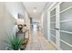 Bright hallway featuring wood-look tile, contemporary lighting and an open floorplan at 8887 Little Bluestem Dr, Land O Lakes, FL 34637